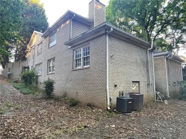 a view of a backyard with plants and large tree