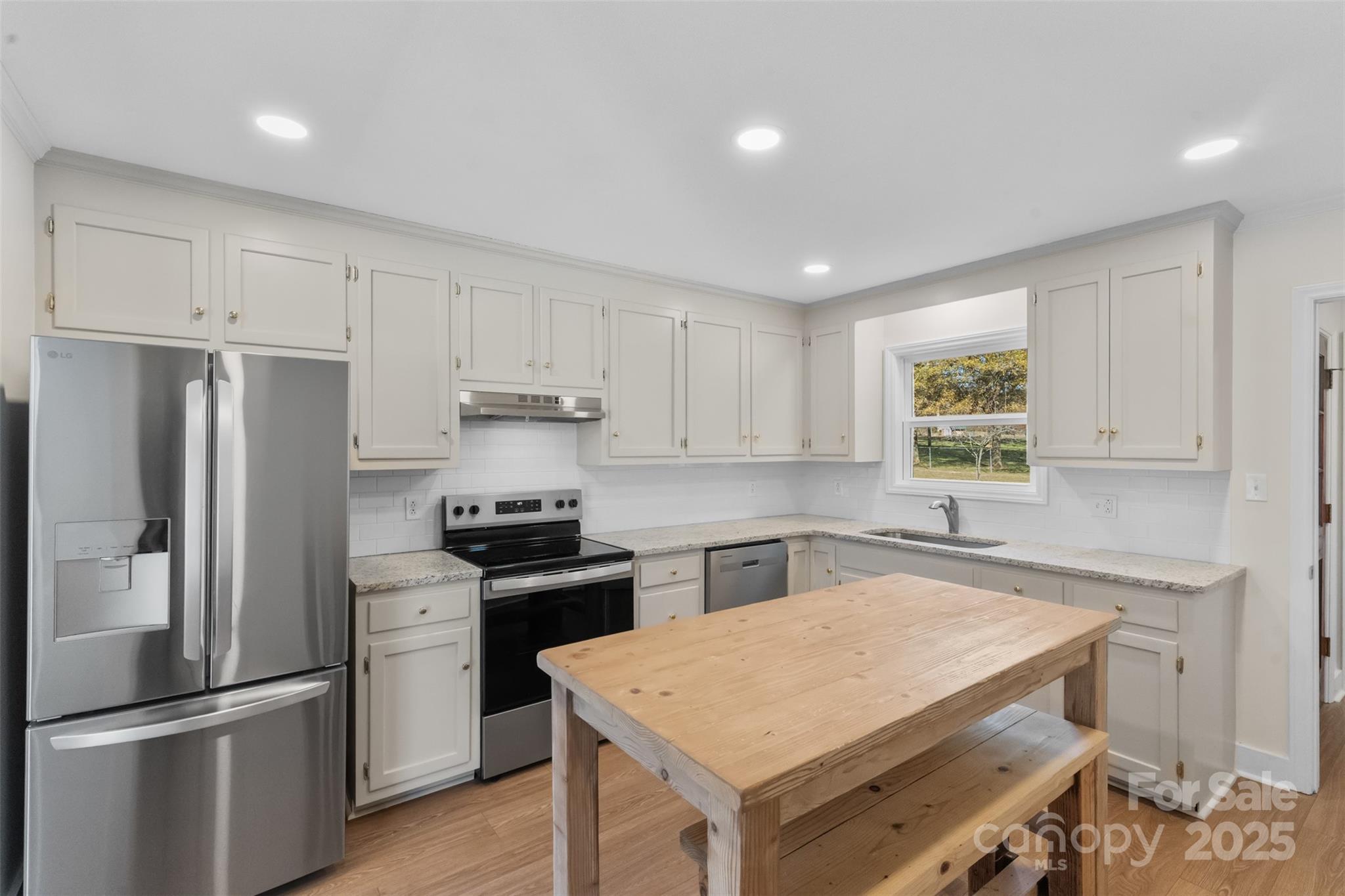 3407 Stonegate Road Monroe, NC 28110 - Photo 11 of 34 a kitchen with white cabinets and stainless steel appliances