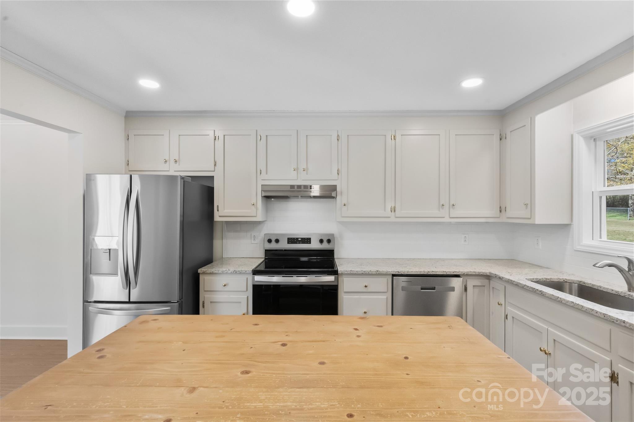 3407 Stonegate Road Monroe, NC 28110 - Photo 13 of 34 a kitchen with granite countertop white cabinets and stainless steel appliances
