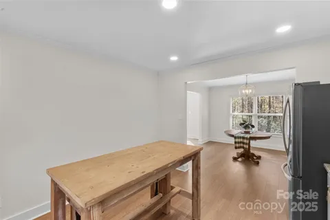 a room with a table chairs and a refrigerator
