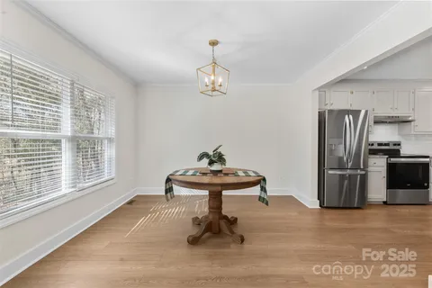 a living room with furniture a table and stainless steel appliances