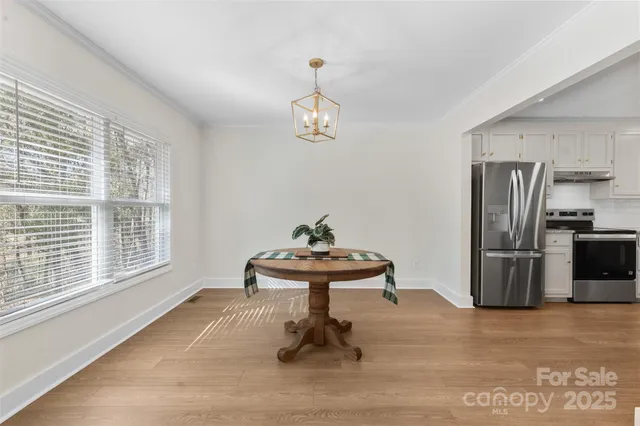 a living room with furniture a table and stainless steel appliances