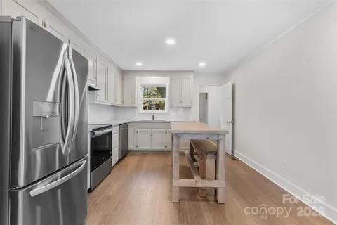 a kitchen with a refrigerator a sink and cabinets
