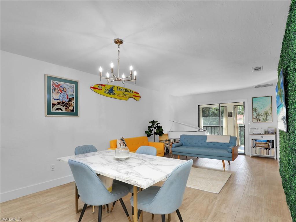 9831 Alabama Street, Unit 5 Bonita Springs, FL 34135 - Photo 11 of 28 Dining room featuring a chandelier and light wood-style flooring