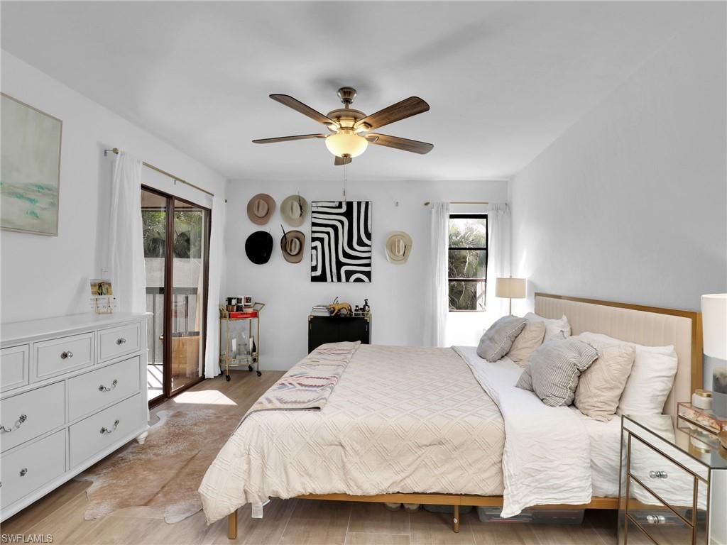 9831 Alabama Street, Unit 5 Bonita Springs, FL 34135 - Photo 17 of 28 Bedroom with multiple windows, access to outside, ceiling fan, and wood finished floors