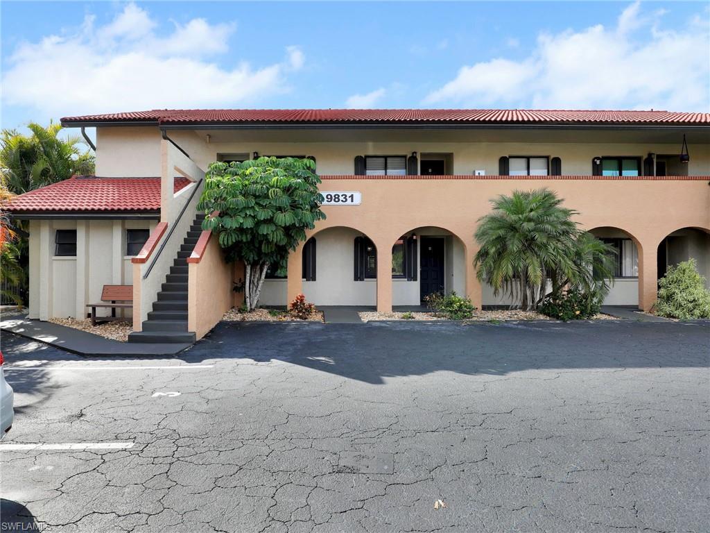 9831 Alabama Street, Unit 5 Bonita Springs, FL 34135 - Photo 2 of 28 View of building exterior with stairway and uncovered parking
