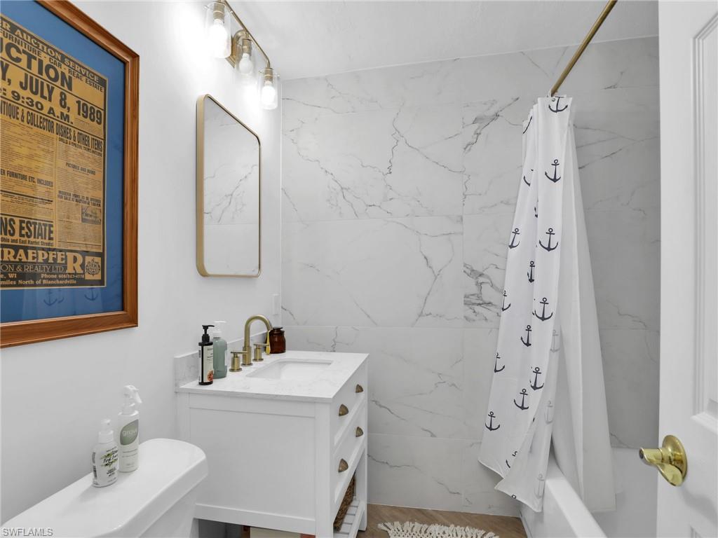 9831 Alabama Street, Unit 5 Bonita Springs, FL 34135 - Photo 21 of 28 Full bathroom with a combined bath / shower with marble appearance and vanity