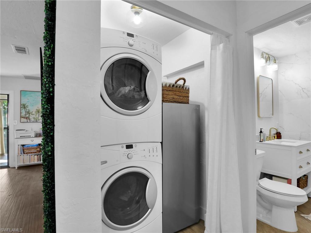 9831 Alabama Street, Unit 5 Bonita Springs, FL 34135 - Photo 23 of 28 Laundry area with estacked washer and dryer and wood finished floors