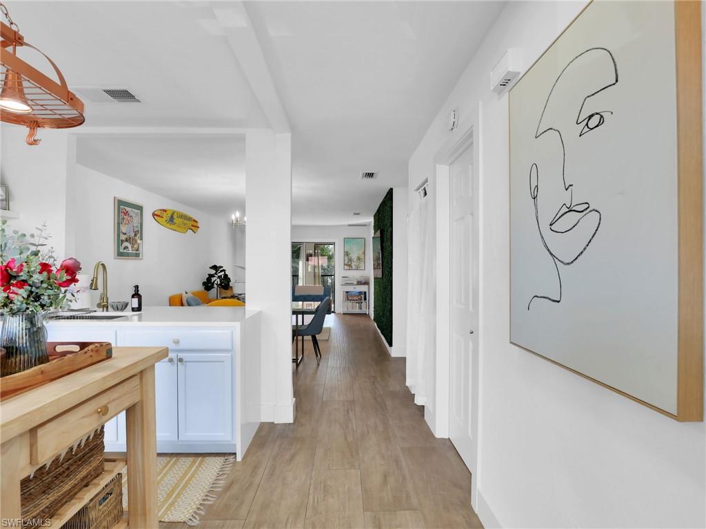 9831 Alabama Street, Unit 5 Bonita Springs, FL 34135 - Photo 4 of 28 Hallway with light wood-style flooring and a chandelier