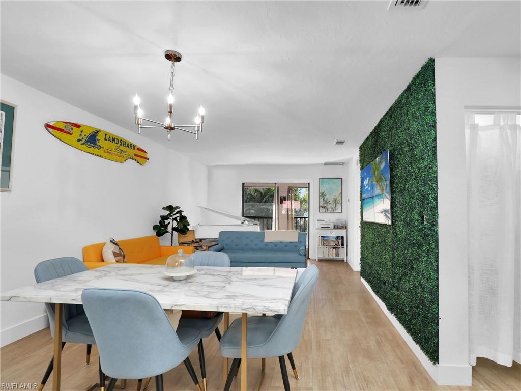 9831 Alabama Street, Unit 5 Bonita Springs, FL 34135 - Photo 9 of 28 Dining room featuring a chandelier and light wood-style floors