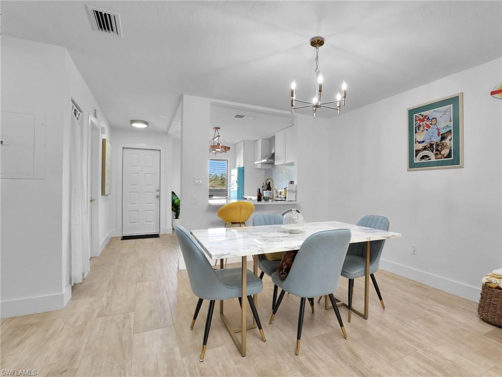 9831 Alabama Street, Unit 5 Bonita Springs, FL 34135 - Photo 10 of 28 Dining room featuring a chandelier and light wood finished floors