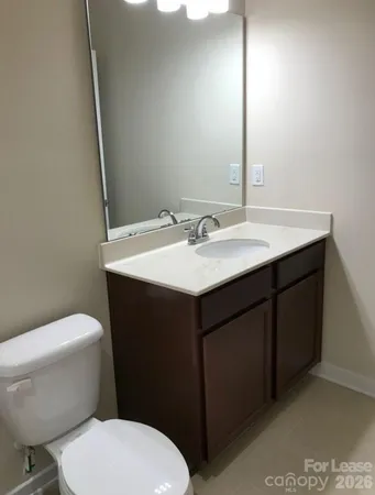 a bathroom with a granite countertop toilet sink and mirror
