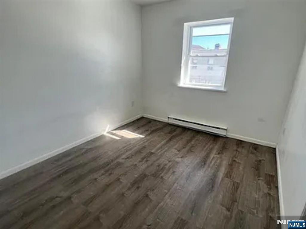 25 Houston Street, Unit 5 Newark, NJ 07105 - Photo 2 of 5 an empty room with wooden floor and windows