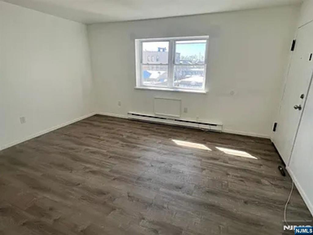25 Houston Street, Unit 5 Newark, NJ 07105 - Photo 3 of 5 an empty room with wooden floor and windows