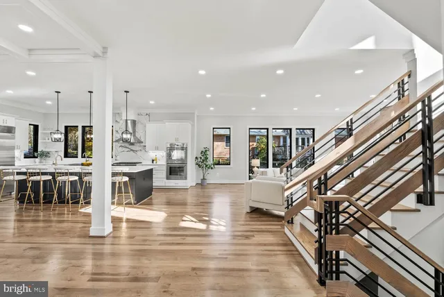 a kitchen with stainless steel appliances kitchen island granite countertop a table chairs and a wooden floor