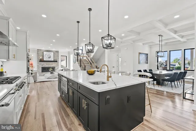a view of a brick house with a wooden fence and a large tree