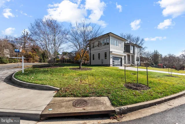 a view of a house with a big yard and large trees