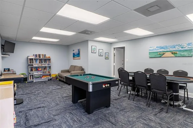a view of swimming pool with outdoor seating and trees in the background