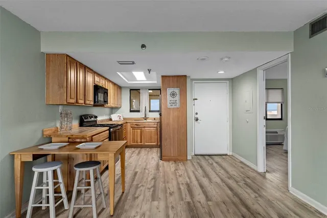 a kitchen with a sink and wooden floor