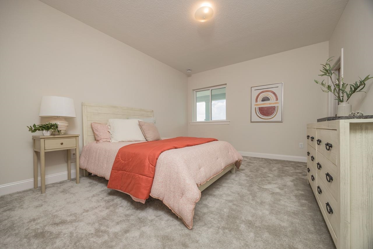 194 Snowbell Court St. Augustine, FL 32095 - Photo 24 of 75 a spacious bedroom with a bed and a painting on the wall