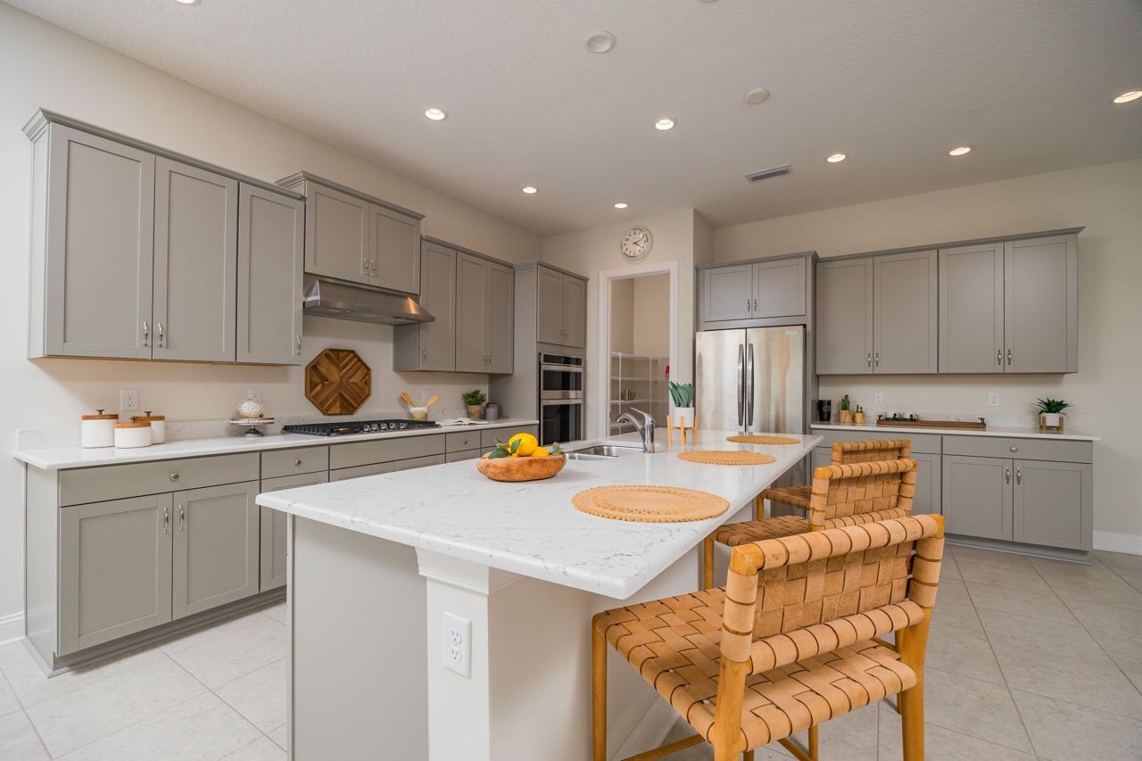 194 Snowbell Court St. Augustine, FL 32095 - Photo 29 of 75 a kitchen with a sink a stove cabinets and wooden floor