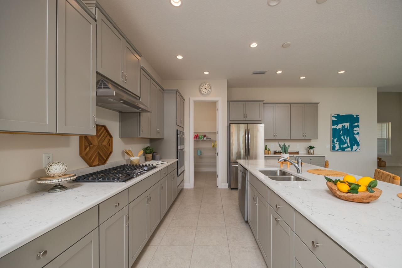 194 Snowbell Court St. Augustine, FL 32095 - Photo 30 of 75 a kitchen with stainless steel appliances granite countertop a sink a stove and a refrigerator