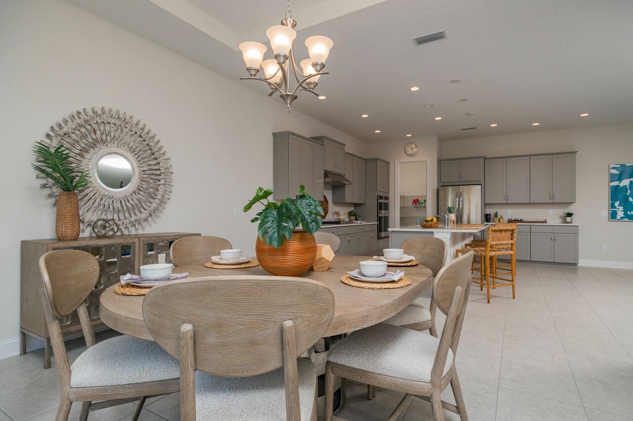 194 Snowbell Court St. Augustine, FL 32095 - Photo 34 of 75 a dining room filled chandelier and kitchen view