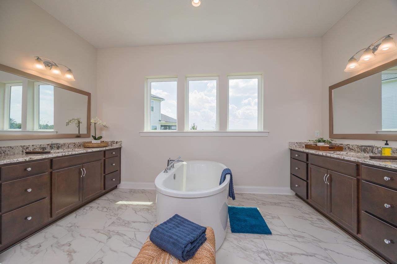 194 Snowbell Court St. Augustine, FL 32095 - Photo 6 of 75 a spacious bathroom with a granite countertop toilet sink and mirror