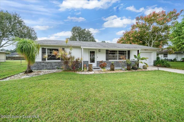 a front view of house with yard and green space
