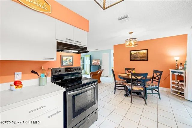 a kitchen with stainless steel appliances a stove a table and chairs