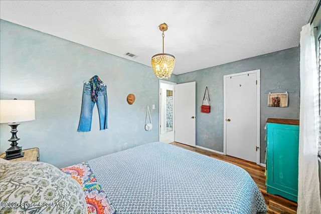 a bedroom with a bed and a chandelier