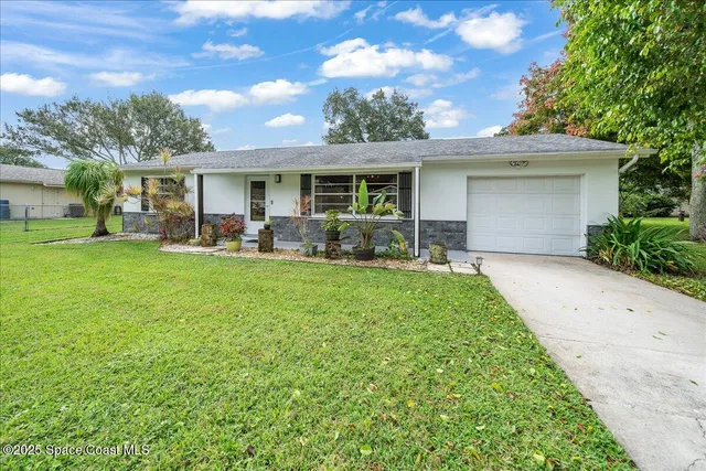 a front view of house with yard and outdoor seating