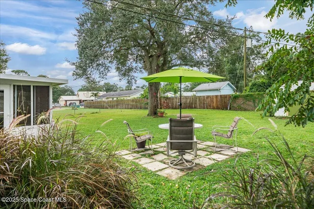 a view of backyard of house with seating space