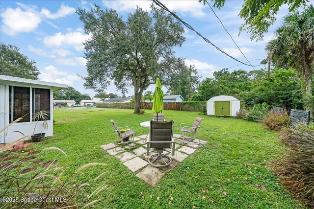 a view of a house with backyard sitting area and garden