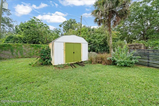a view of a backyard with a garden and entertaining space