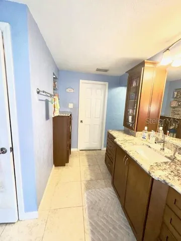 a bathroom with a granite countertop sink a mirror and a bathtub