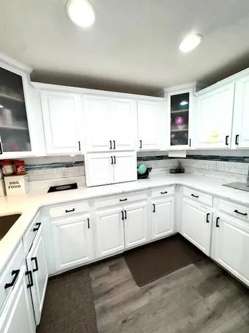 a large white kitchen with granite countertop white cabinets and a sink