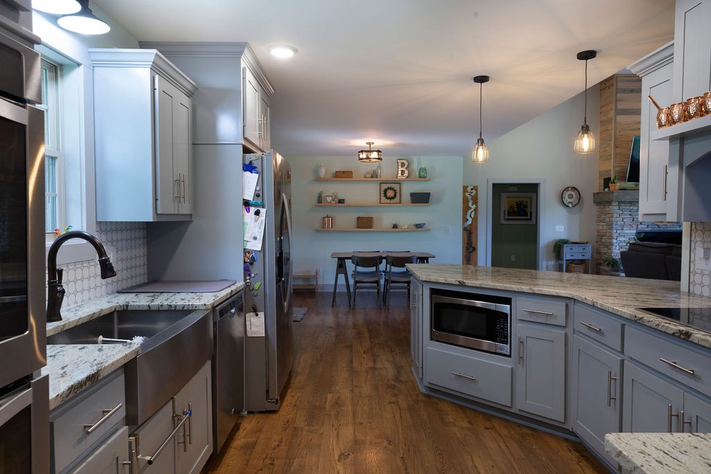 1701 Rock Bridge Road Bethpage, TN 37022 - Photo 3 of 29 a kitchen with stainless steel appliances granite countertop a stove a sink dishwasher and a microwave with wooden floor