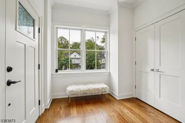 a view of a bedroom with wooden floor and a window