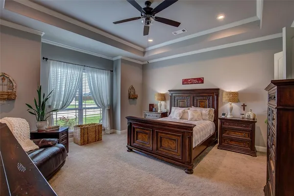 a spacious bedroom with a bed a couch and a chandelier