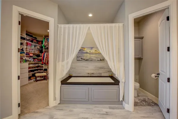 an entryway in a hall with wooden floor and a cabinet