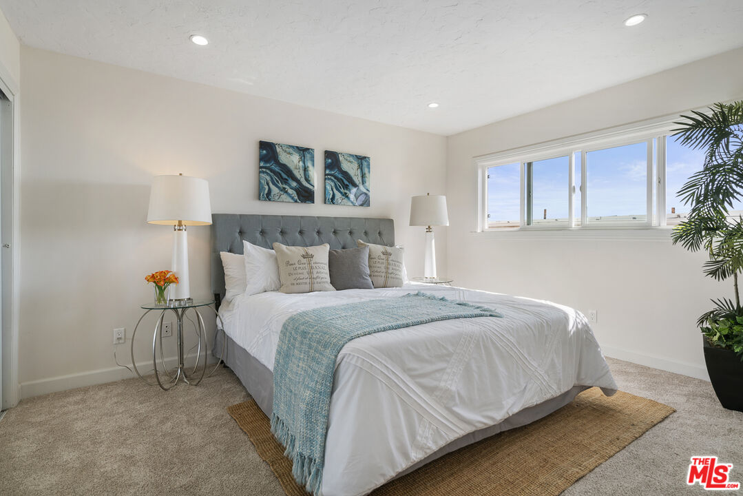 18147 Coastline Drive, Unit 6 Malibu, CA 90265 - Photo 11 of 26 a bedroom with a bed and a painting on the wall