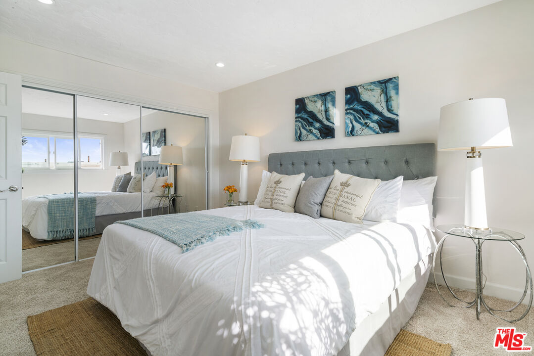 18147 Coastline Drive, Unit 6 Malibu, CA 90265 - Photo 12 of 26 a bedroom with a large bed and a painting on the wall