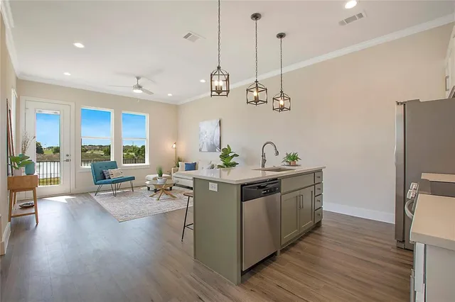 a view of living room with kitchen island furniture a flat screen tv and a large window