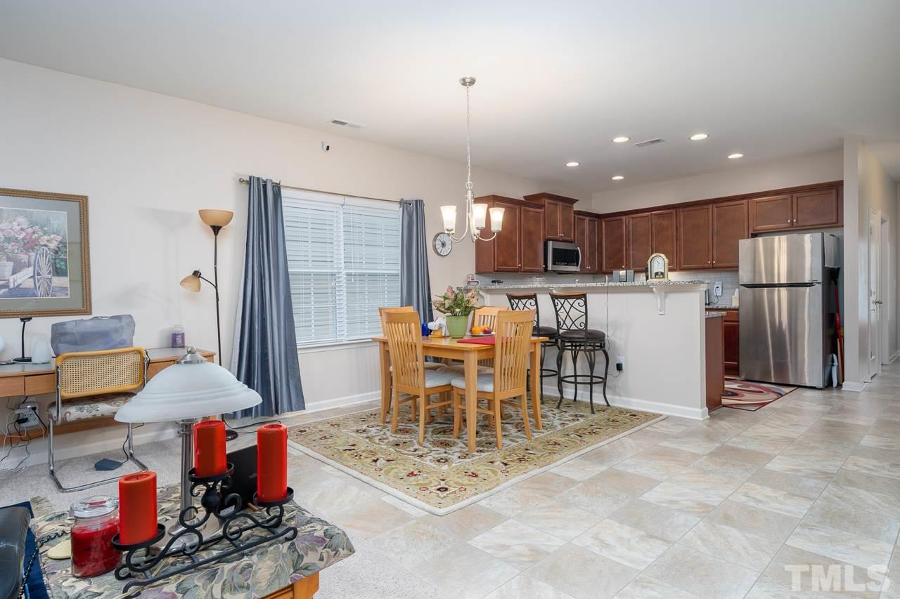3609 Waleback Lane Raleigh, NC 27610 - Photo 3 of 18 a kitchen with stainless steel appliances kitchen island granite countertop a refrigerator and a dining table