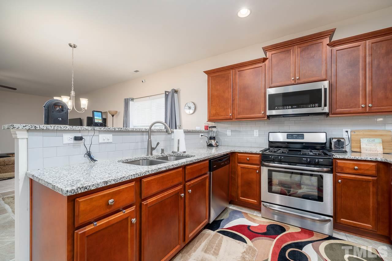3609 Waleback Lane Raleigh, NC 27610 - Photo 4 of 18 a kitchen with stainless steel appliances granite countertop a sink stove and microwave