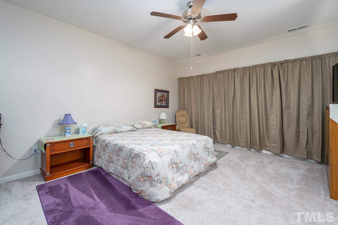 3609 Waleback Lane Raleigh, NC 27610 - Photo 7 of 18 a bedroom with a bed and a chandelier
