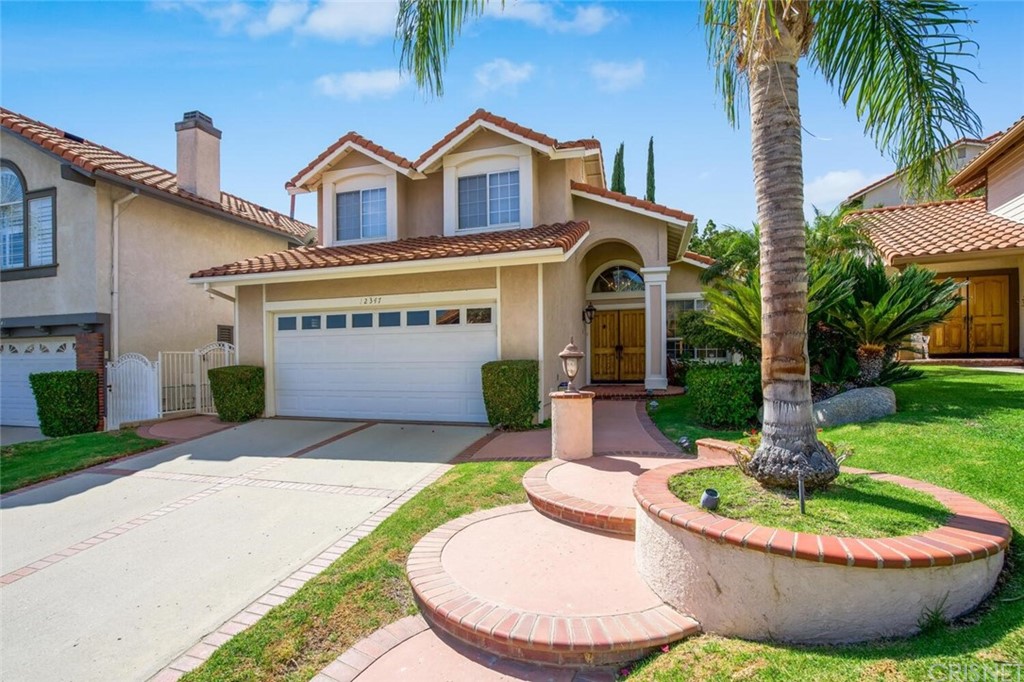a front view of a house with a garden and patio