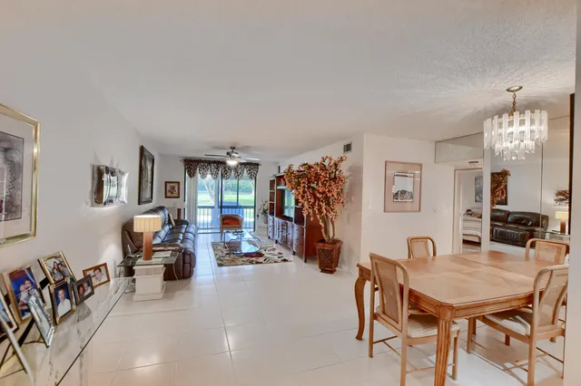 a living room with furniture a flat screen tv and a chandelier