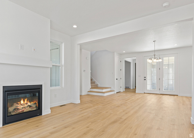 11214 South Easy Bee Road, Unit 270 South Jordan, UT 84009 - Photo 5 of 31 Spacious living area featuring a modern fireplace with a white mantel, light wood-finish flooring, recessed lighting, and a chandelier